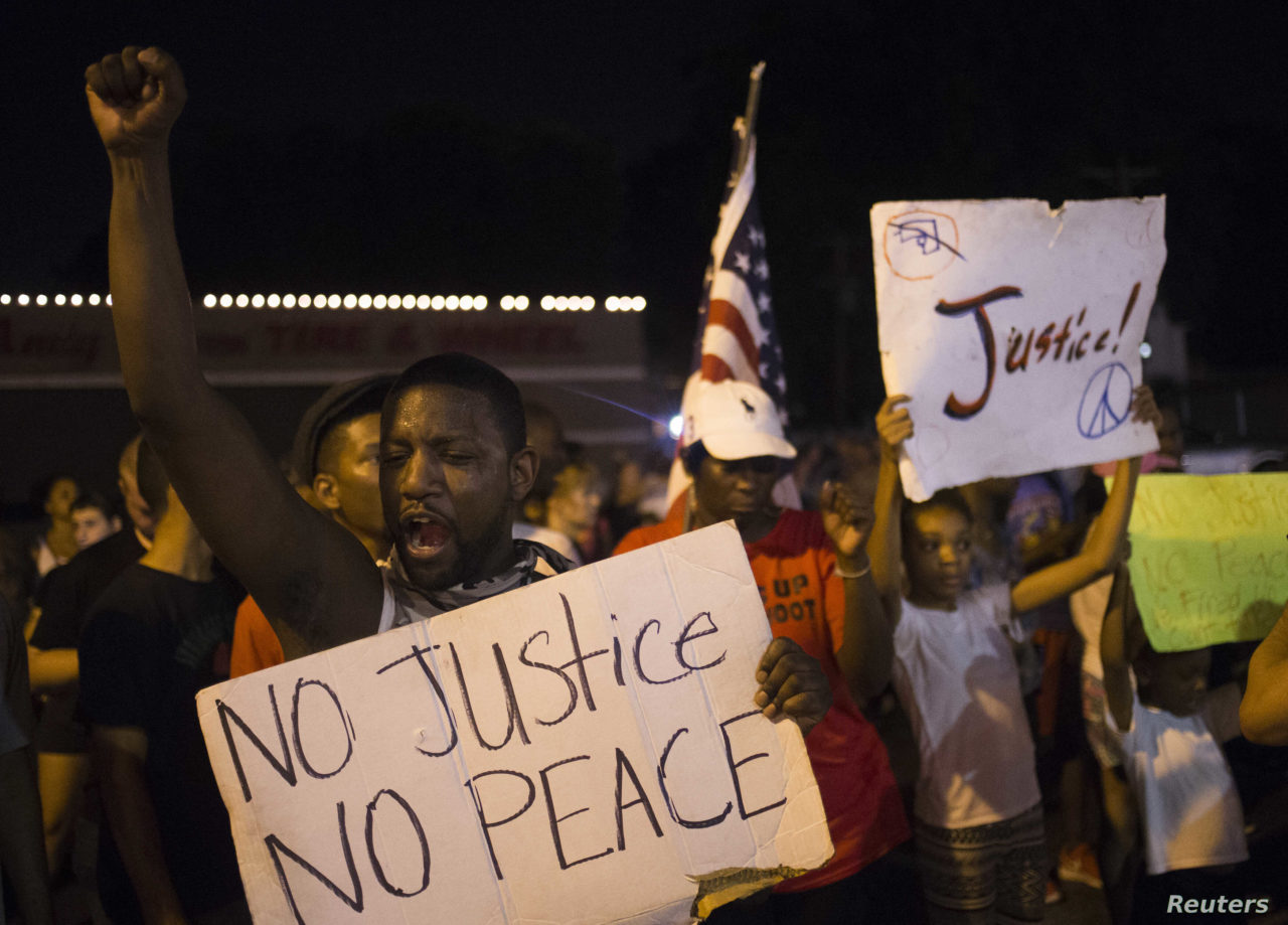 Demonstrators protest the killing of unarmed teen Michael Brown across the street from the Ferguson Police Department in Ferguson, Missouri